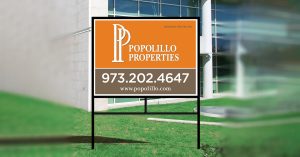 Commercial real estate sign in a metal frame outside a building